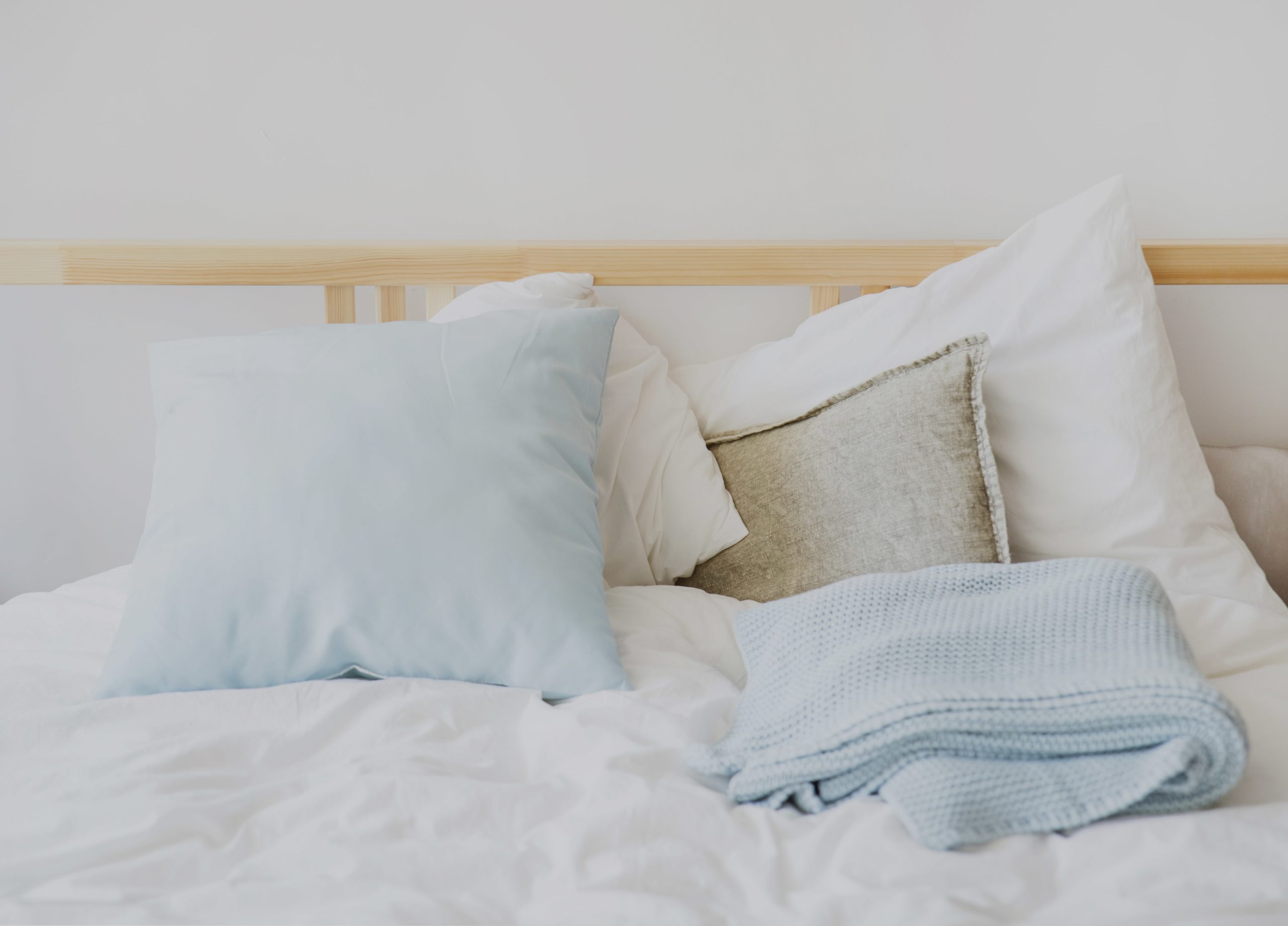 Zoom sur un lit avec des oreillers, couverture avec un sommier en bois