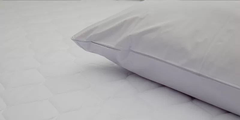 Zoom sur un matelas avec un oreiller par dessus